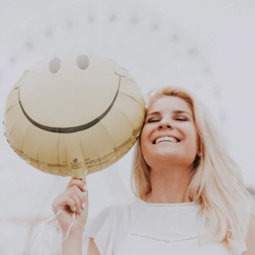 Woman smiling with smiley balloon